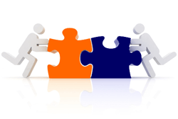 Two people working in collaboration to put puzzle pieces together.